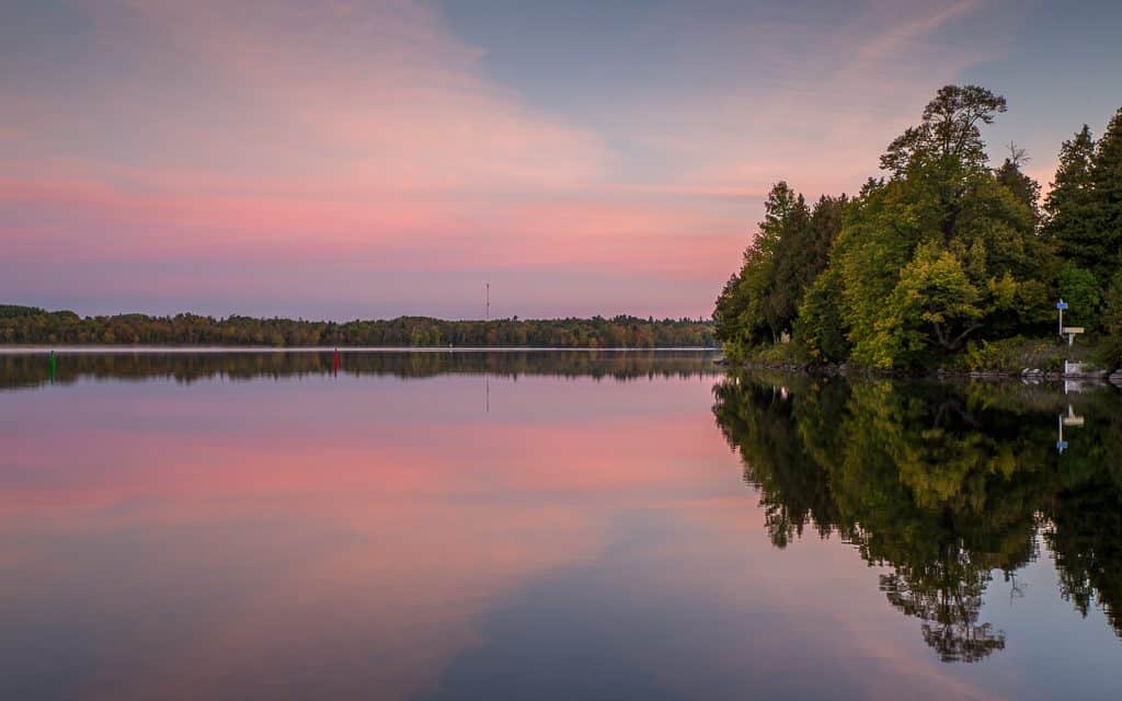Pink sky in the morning over a calm Peninsula Lake.